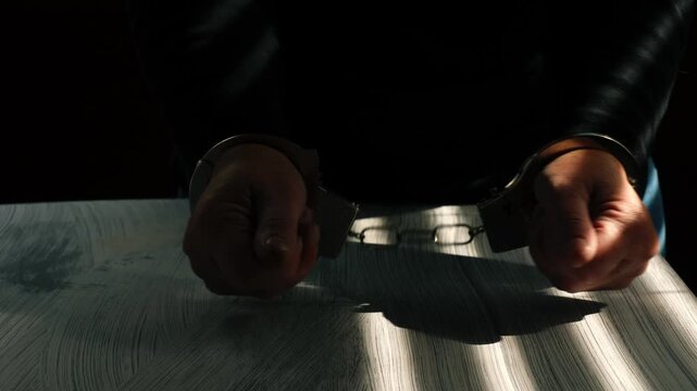 Criminal in handcuffs in police room