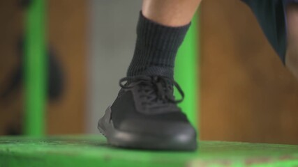 Dynamic close-up of black athletic shoes with gray socks in motion during functional box jump exercise - Powered by Adobe