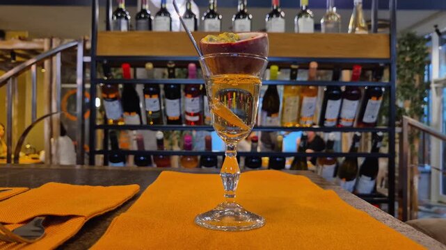 A glass with an alcoholic drink decorated with fresh passion fruit, close-up