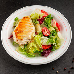 Grilled chicken breast salad chicken breast tomato, green leaf lettuce, salad mix snack vegetable tasty snack fresh gourmet food background on the table rustic top view copy space keto and paleo diet
