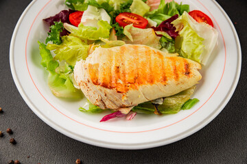 Grilled chicken breast salad chicken breast tomato, green leaf lettuce, salad mix snack vegetable tasty snack fresh gourmet food background on the table rustic top view copy space keto and paleo diet