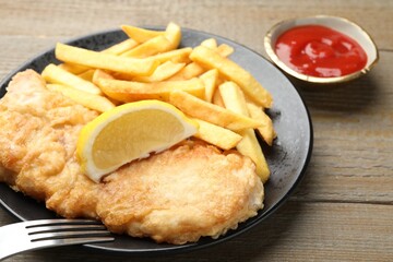 British Traditional Fish and chips served on wooden table, closeup