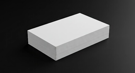 A thick stack of pristine white cards rests on a sleek dark gray surface