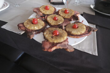 a plate of delicious chuleta with pineapple
