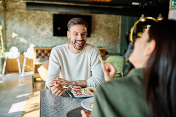 Portrait of ayoung romantic couple in restaurant having lunch