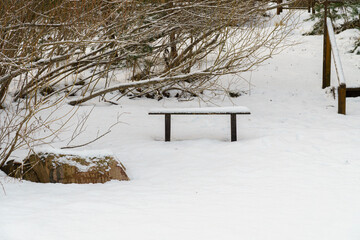 Minimalist Wooden Bench Covered in Snow on a Cold Winter Day