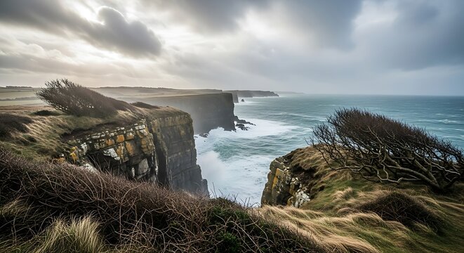 Dramatic coastal landscape with cliffs facing ocean under cloudy sky