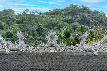 Dragon ornaments on the roof of the temple in Trang An Scenic Landscape Complex, Ninh Binh, Vietnam. Tam Coc National Park