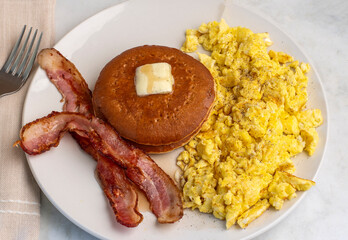 scramble eggs  served with pancakes with bacon