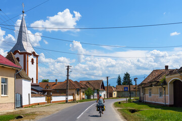 Cycling past a village church on a sunny day
