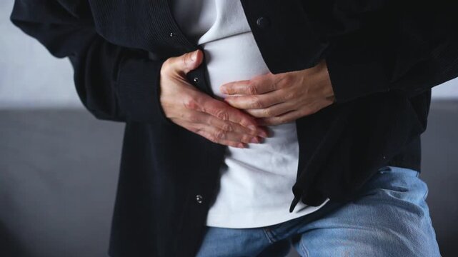 Abdominal cramps and pain due to overeating.
Bloating and constipation issues.
A man clutches his stomach during severe pain due to food poisoning.
Intestinal pain, spasms, constipation