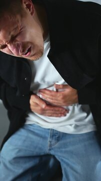 Abdominal cramps and pain due to overeating.
Bloating and constipation issues.
A man clutches his stomach during severe pain due to food poisoning.
Intestinal pain, spasms, constipation