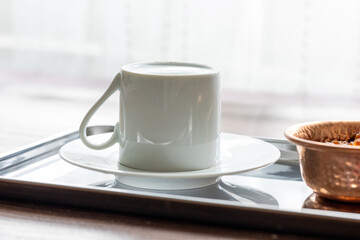 Close-Up of Traditional Turkish Coffee in a White Cup on a Metal Tray with Dried Grapes in a Copper Dish
