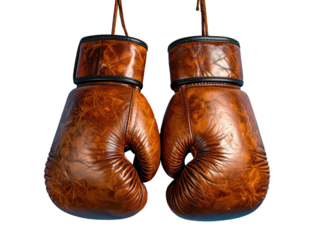 Two vintage, leather boxing gloves hanging against a dark background, showing texture and detail