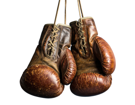 Two worn brown leather boxing gloves suspended against a black background, laces visible