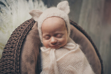 A newborn baby is wrapped in diapers with a wool cap in a basket. Swaddling, maternity hospital, family, ivf, life planning, parenting. A mother's love for her child. Baby food. High quality photo