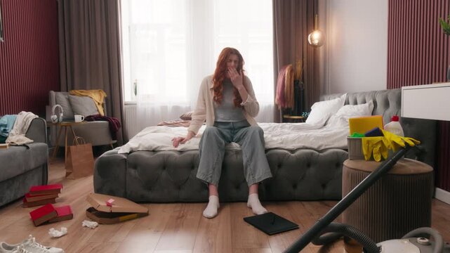 Caucasian woman yawn in messy dirty bedroom in morning yawning after party mess disorder tired girl overwhelmed homeowner at home cleaning stress female housewife lazy clutter chaos routine chore