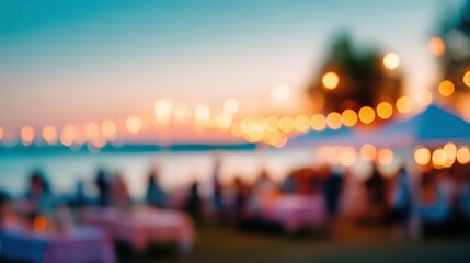 Obraz premium Blurred outdoor evening party background with glowing string lights and people dining near the water at sunset, festive summer celebration atmosphere perfect for event or lifestyle design use