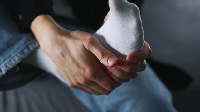A man sits on a sofa, clutching his sore heel.
Foot pain from an injury.
The man suffers from leg pain.
A broken leg and joint problems.