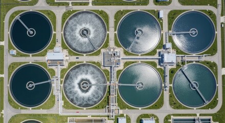 Aerial view of a wastewater treatment plant with seven circular tanks and a green roof.