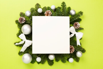 Festive Christmas tree branches with mock up black on color background, top view