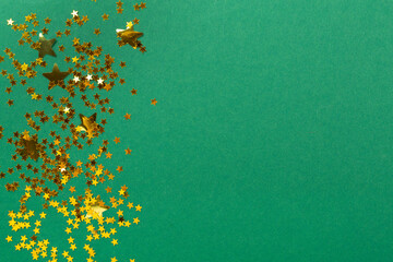Golden star shape confetti on color background, top view