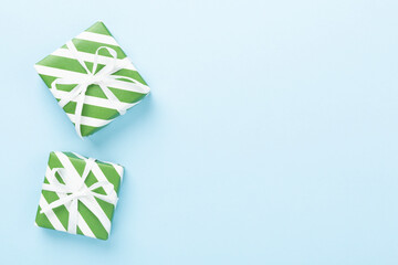 Striped Christmas gift boxes on color background, top view
