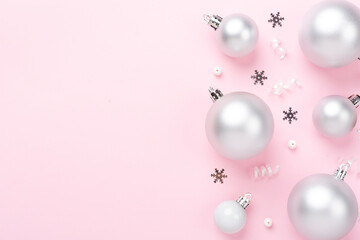 Grey Christmas balls with decor on color background, top view