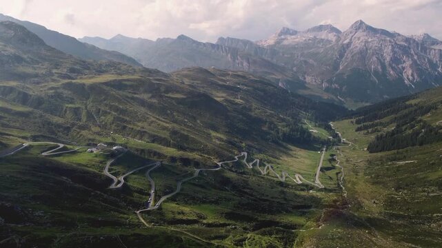 Drone view on Splugen Pass hairpin turns at sunset - Italy Switzerland Alps