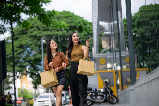 Two young asian women shopping in city street