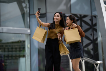 Asian friends shopping taking selfie with bags and credit card
