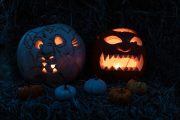 Halloween. Carved Halloween pumpkins glowing with candlelight inside at night, spooky and festive atmosphere with dark background.