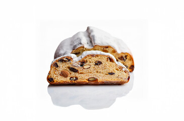 Traditional German Stollen Bread Isolated on White Background. A delicious German Christmas stollen bread filled with marzipan, nuts, and dried fruits, covered with powdered sugar.