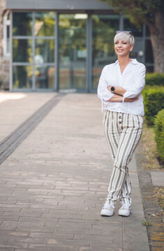 Full length body of beautiful woman with crossed arms. Pretty adult woman looking to side.