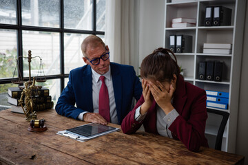 Lawyer comforting crying client receiving bad news at office
