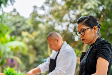 Fototapeta premium Chefs preparing fresh ingredients outdoors for country restaurant
