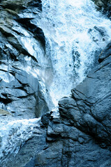 Powerful waterfall cascading down rugged rocky cliffs a dynamic natural landscape in motion perfect for travel and environmental themes © Gullfam