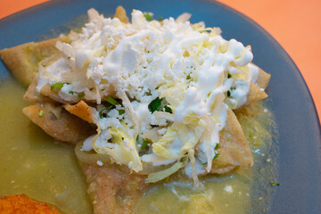 Platillo mexicano chilaquiles a base de tortillas cortadas con chile verde y queso