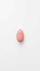 Happy pink egg with a face on a white solid background, studio shot.