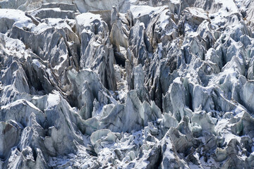 Jagged ice formations on a snowy mountain slope