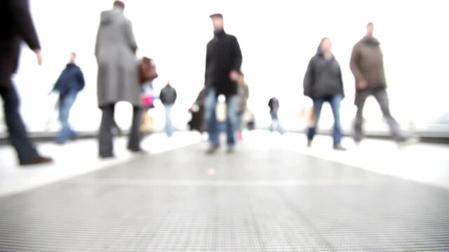 Abstract People. Defocused in-camera footage of people walking candidly around the camera in a bleached futuristic landscape.