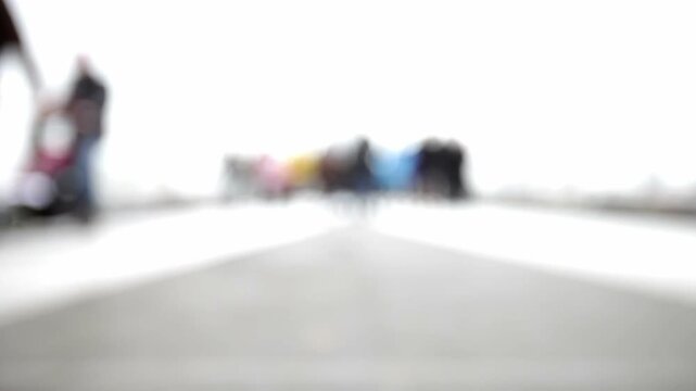 Abstract People. Defocused in-camera footage of people walking candidly around the camera in a bleached futuristic landscape.