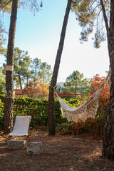 White cloth hammock hanging between two trees at sunset in a mountain village