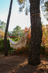 White cloth hammock hanging between two trees at sunset in a mountain village