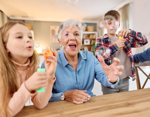 Portrait of grandparents and grandchildren having fun  blowing soap  bubbles together at home