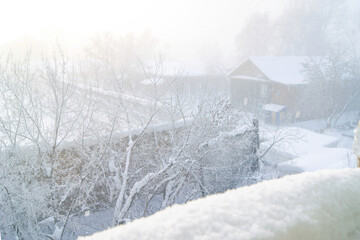 Old wooden house with frosted garden in Tomsk city during harsh Siberian winter. Concepts of Russian provincial heritage, northern craftsmanship, and rural authenticity in snowbound environment.