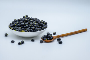 흰색 그릇과 나무 숟가락에 담긴 검은콩