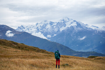 Obraz premium A hiker looking out over snow-capped mountains, Caucasus Mountains, Georgia
