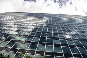 modern glass office building facade looking up at sky low angle view