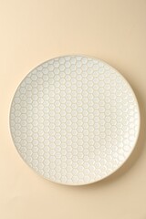 Stylish ceramic plate on beige background, top view